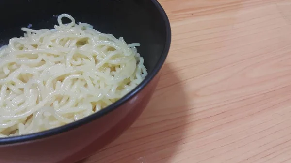 木製の床の上のボウルに渦巻く麺やスパゲッティパスタのクローズアップビュー — ストック写真