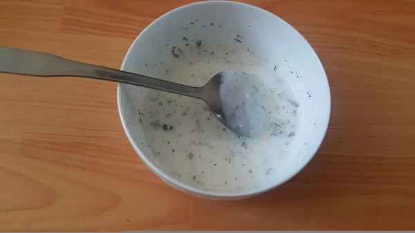 Cierre de cuajada simple o yogur o dahi en un tazón de cerámica blanca con cuchara de plata —  Fotos de Stock