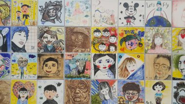 Anılar için duvardaki insanların resimleri ve heykel yüzleri.