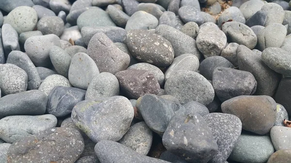 Rotskeien, kleine, ronde, gladde rotsen. Textuur achtergrond voor tekst — Stockfoto