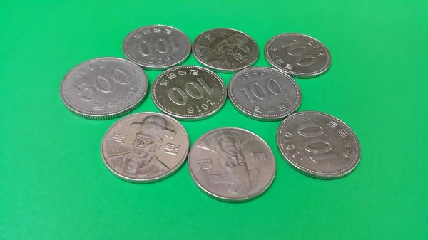 Korejská mince roztroušené po zelené podlaze — Stock fotografie