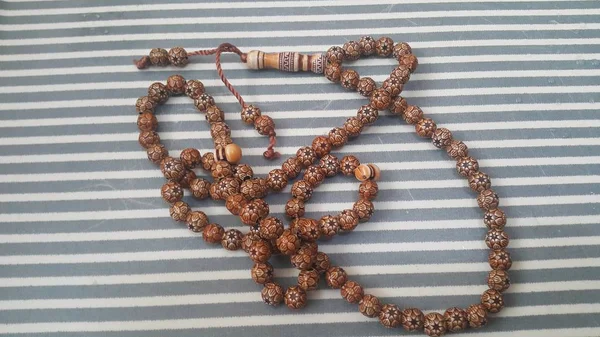 Beautiful wooden prayer beads or rosary with a striped background — Stock Photo, Image