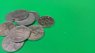 Kore Won sikke yeşil bir zemin üzerinde dağılmış