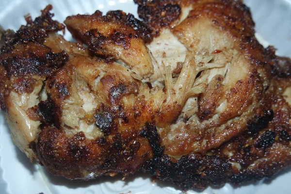 Close up de pedaços de frango assado em um prato branco servido para refeição — Fotografia de Stock