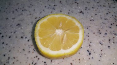 Gri zeminüzerine yerleştirilen sarı peelingile taze limon dilimleri