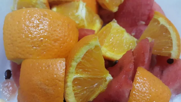 Vista de cerca de las rebanadas de frutas mixtas de naranjas cítricas y sandía roja dulce —  Fotos de Stock