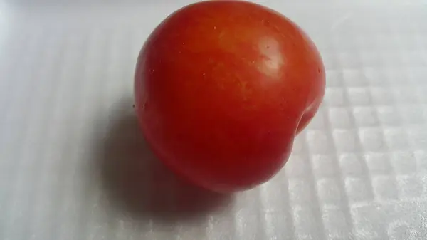 Vista de perto da ameixa vermelha em um fundo cinza branco — Fotografia de Stock