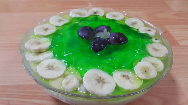 Creamy lezat hijau jelly manis dengan irisan pisang berlapis di permukaan — Stok Foto