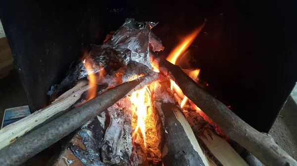 Feu sur les bûches dans la casserole avec des braises et du charbon brûlant et des flammes flamboyantes . — Photo