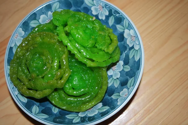 Crispy sweet Asian dessert green Jalebi cooked and served in ceramic plate. — Stock Photo, Image