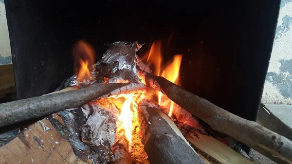 Fuoco su tronchi in pentola di fuoco con braci e carbone ardente e fiamme ardenti . — Foto Stock