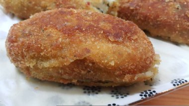 Baharatlı ve lezzetli kroket ahşap zemin üzerinde seramik tabak servis