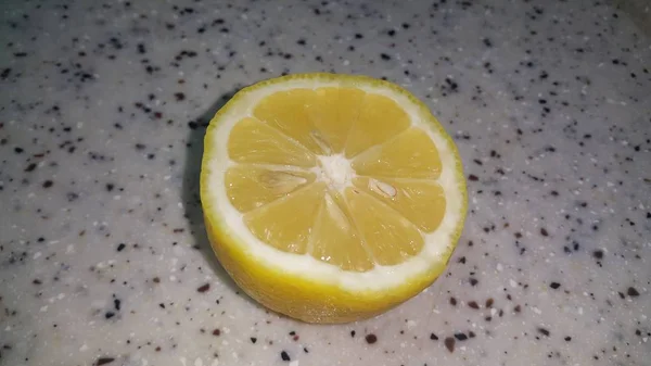 Fresh lemon slices with yellow peelings placed on a grey floor — Stock Photo, Image