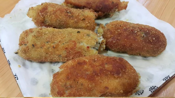 Kroket pedas dan lezat disajikan dalam piring keramik di atas lantai kayu — Stok Foto