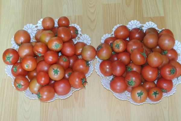 Close-up view of red tomatoes in white basket on a wooden floor in market — Stock Photo, Image