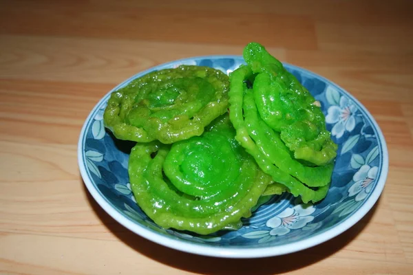 Crispy sweet Asian dessert green Jalebi cooked and served in ceramic plate. — Stock Photo, Image