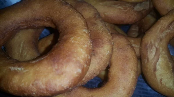 Nahaufnahme einer Reihe frisch zubereiteter brauner und leckerer Donuts. — Stockfoto