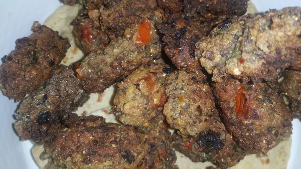 Delicioso kebab redondo picante frito servido em placa de cerâmica branca — Fotografia de Stock