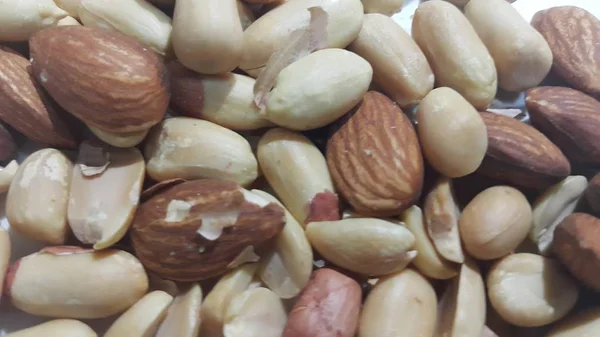 Dried and roasted  peanuts and almonds out of shell. A fruit for background — Stock Photo, Image