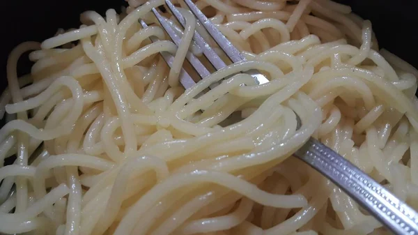 Nahaufnahme Wirbelnder Nudeln Oder Spaghetti Einer Schüssel Mit Silberner Gabel — Stockfoto