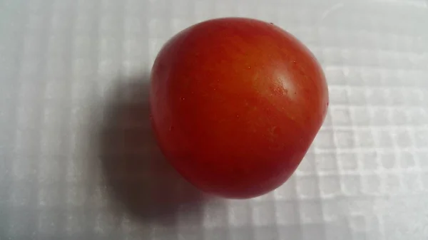 白い灰色の背景に赤い梅のクローズアップビュー 角度から見ると新鮮に収穫された梅がハート型に見えます — ストック写真