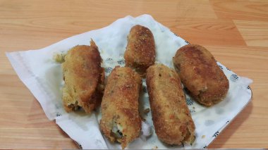 Closeup perspective view of home made spicy and delicious croquettes served in ceramic plate over wooden floor clipart
