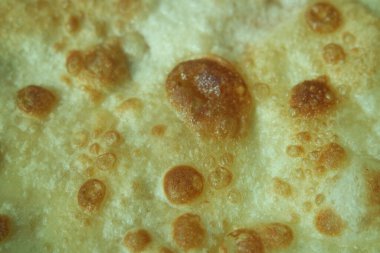 Yakından bakınca, paratha roti adı verilen yağda sade ekmek elde ediliyor. Paratha Hindistan, Pakistan ve diğer Güney Asya ülkelerinde popülerdir. Ekmek için doku.