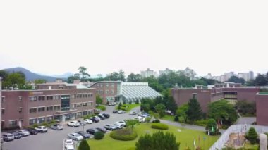 Ağaçlar ve yeşil çimenler arasında güzel bir bina manzarası.