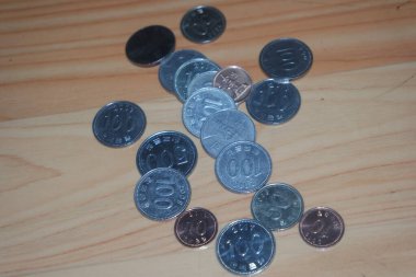 Gümüş parlayan Kore won 'u ahşap zemine saçılmış..