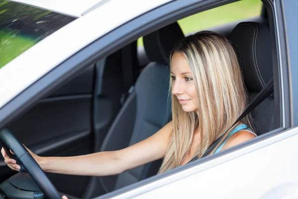 Mujer joven se concentra en conducir su vehículo — Foto de Stock