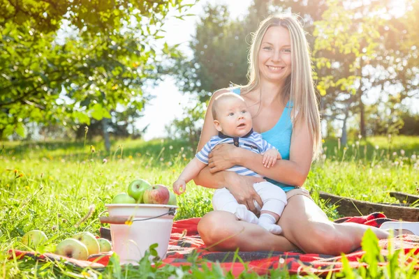 Belle mère avec bébé assis à l'extérieur sur une couverture — Photo