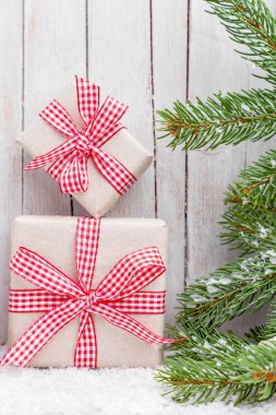 Ahşap arka plan üzerinde kar ile Noel hediyeleri