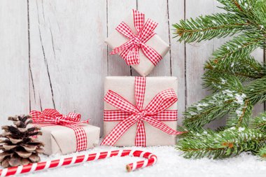 Ahşap arka plan üzerinde kar ile Noel hediyeleri