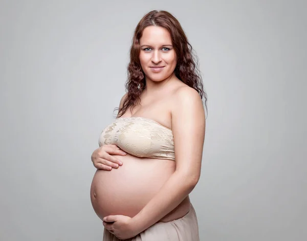 Portret kobiety w ciąży z kręconymi włosami — Zdjęcie stockowe