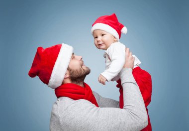 Babamla kutlama Noel Noel Baba şapkaları giyen erkek bebek
