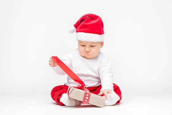 Schattig baby dragen een kerstmuts openen Kerst presenteert — Stockfoto