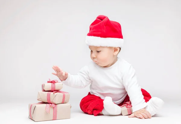 Adorable bébé portant un chapeau de Père Noël ouverture cadeaux de Noël — Photo