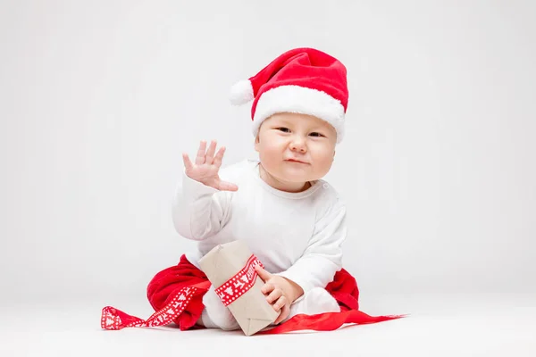 Schattig baby dragen een kerstmuts openen Kerst presenteert — Stockfoto