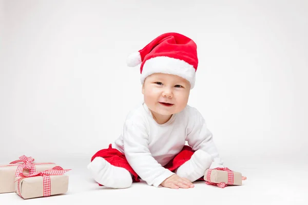 Bebek Noel açılış Noel Baba şapkası giyen sunar — Stok fotoğraf