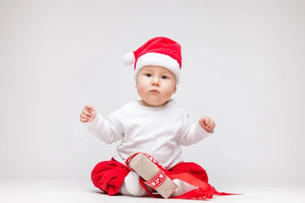 Schattig baby dragen een kerstmuts openen Kerst presenteert — Stockfoto
