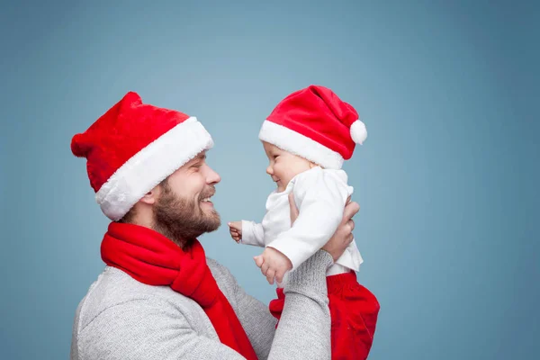 Pai com menino vestindo chapéus de Papai Noel celebrando o Natal — Fotografia de Stock