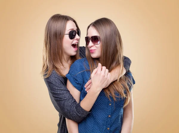 Studioporträt von jungen Zwillingsschwestern, die sich umarmen — Stockfoto
