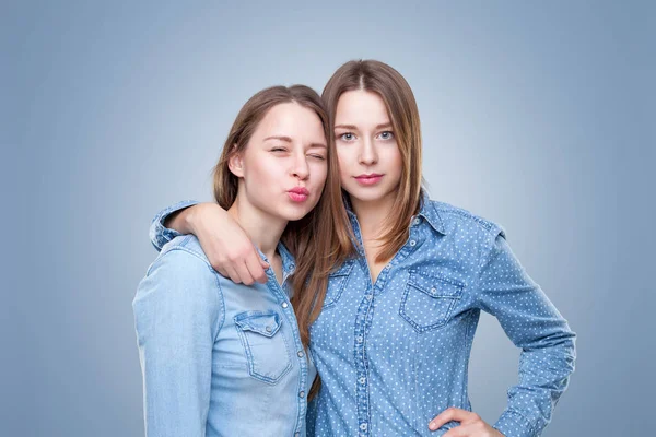 Студийный портэйт молодых сестер-близнецов, обнимающих — стоковое фото