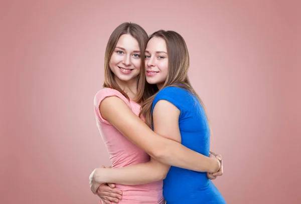 Estudio portait de hermanas gemelas jóvenes abrazando —  Fotos de Stock