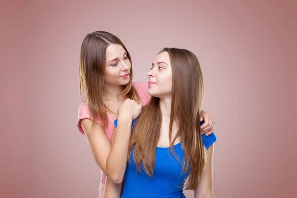 Estudio portait de hermanas gemelas jóvenes abrazando —  Fotos de Stock