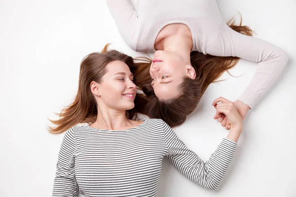 Retrato de hermanas felices tumbadas en el suelo —  Fotos de Stock