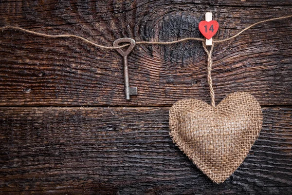 Concetto d'amore. Chiave vecchia e un cuore su sfondo di legno — Foto Stock