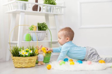 Paskalya yumurtası avı. Evde Paskalya yumurtaları ile oynayan sevimli çocuk