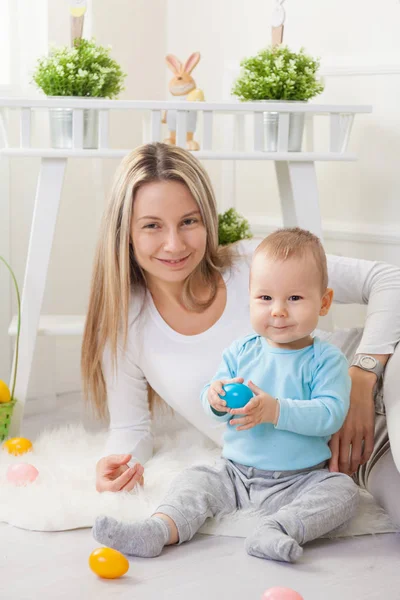 Mère enchantée et son enfant profitant de la chasse aux œufs de Pâques à la maison — Photo