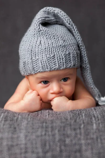 Bonito recém-nascido vestindo um chapéu cinza bonito — Fotografia de Stock